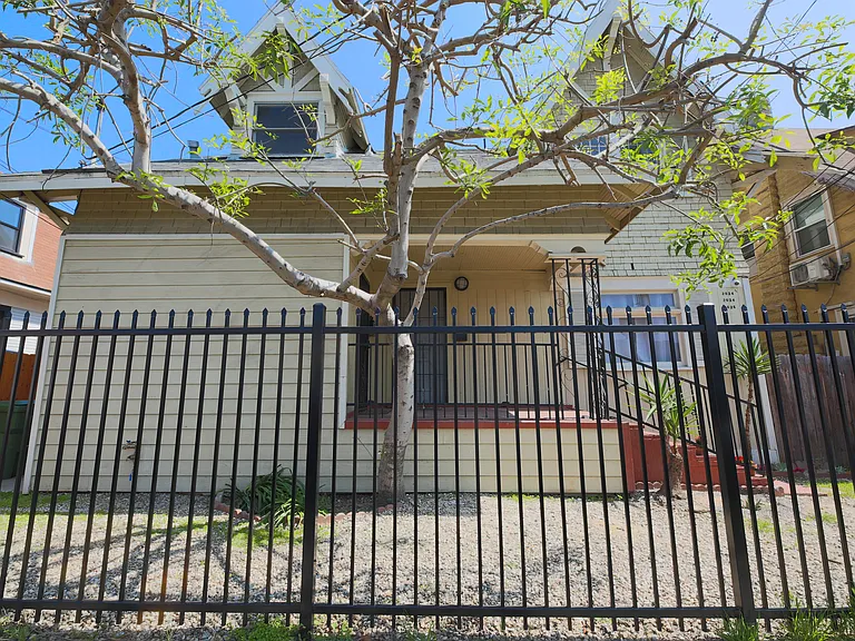 Front of house, security fence, note also that property has security cameras