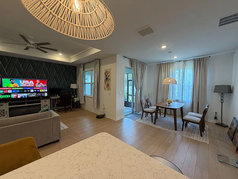 Open-concept living and dining area with large windows, patio access, and space for a full seating setup and dining table.