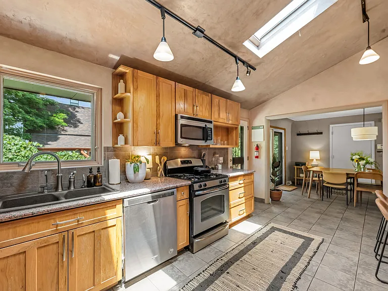 Kitchen with gas range and in-unit washer/dryer, opens to dining area and includes office nook