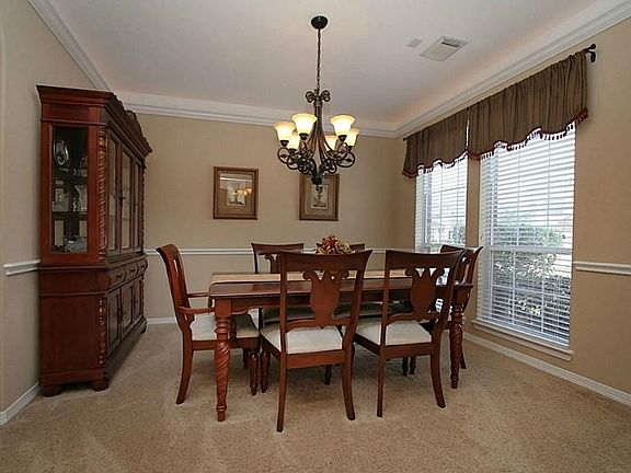 Up-light crown molding, and chair rail molding adorn the elegant formal dining room.