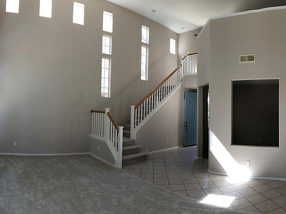 Panorama showing large cathedral ceilings in living/dining room, looking back towards the front door. Bonus room seen under the loft.