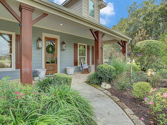 Charming front entry with gas coach lights and brick paver front porch. Corbel details, shutter, dormers and porch swing.