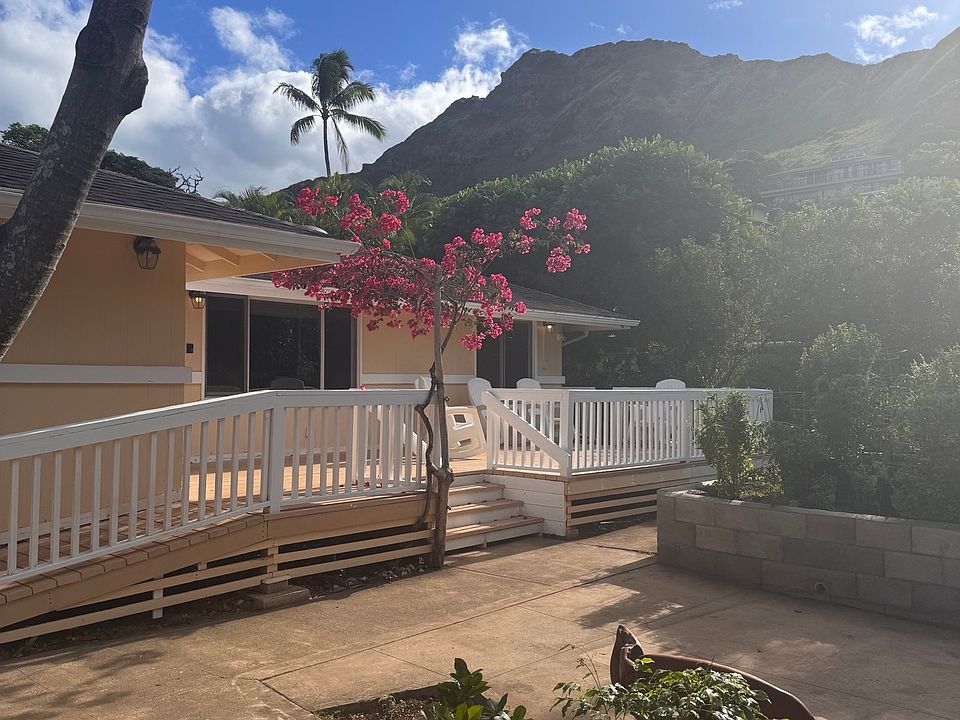 Front view of property. Front deck recently refinished, cute garden view.