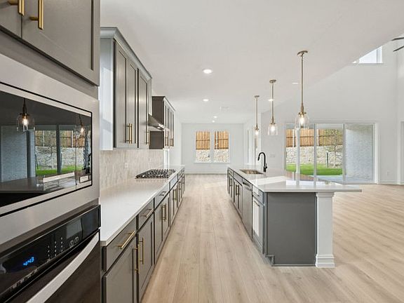 Eat-in island and pendant lighting in kitchen photos may depict options and features that aren t av