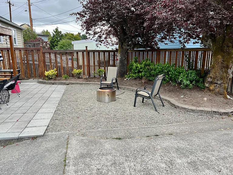 Low maintenance back yard with pavers, gravel and parking for two cars outside of the garage.