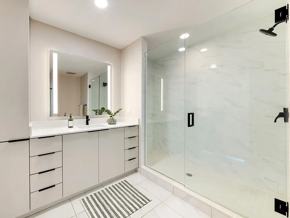 Tower Building - Renovated II bath with white quartz countertop, light grey cabinetry, and tile flooring