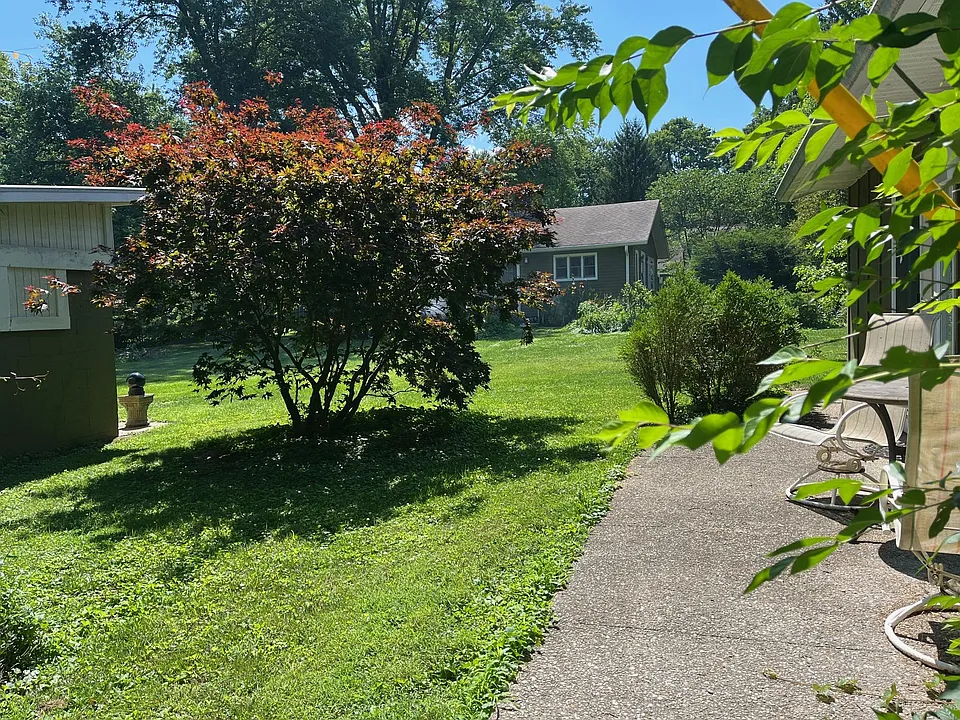 View of back patio from the East. Outbuilding to the left house on property straight ahead. A very nice couple live there, they are quiet and keep to themselves.