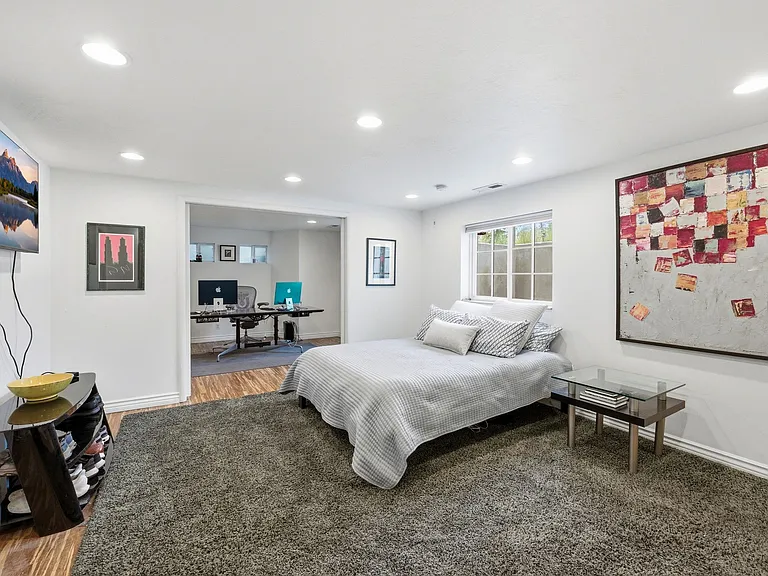Main room on the lower level. Can be used as additional family room with adjacent bedroom and bathroom or as a master suite and office as pictured.