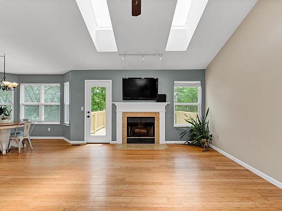 Great room and breakfast room view from entryway. Notice the skylights, fireplace, bay window and entry to the new deck.