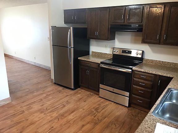 Kitchen looking into living room, coat closet on left
