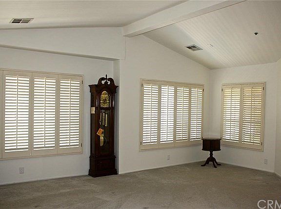 Spacious & bright living room with lots of windows and plantation shutters