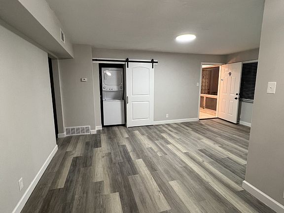 Standing in the dining room looking at the living room and in-unit laundry.