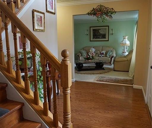 Two Story entry with cat walk and wood floors through to family room.