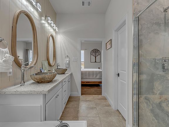 View of newly redesigned master bathroom suite from closet door looking back towards the master bedroom.