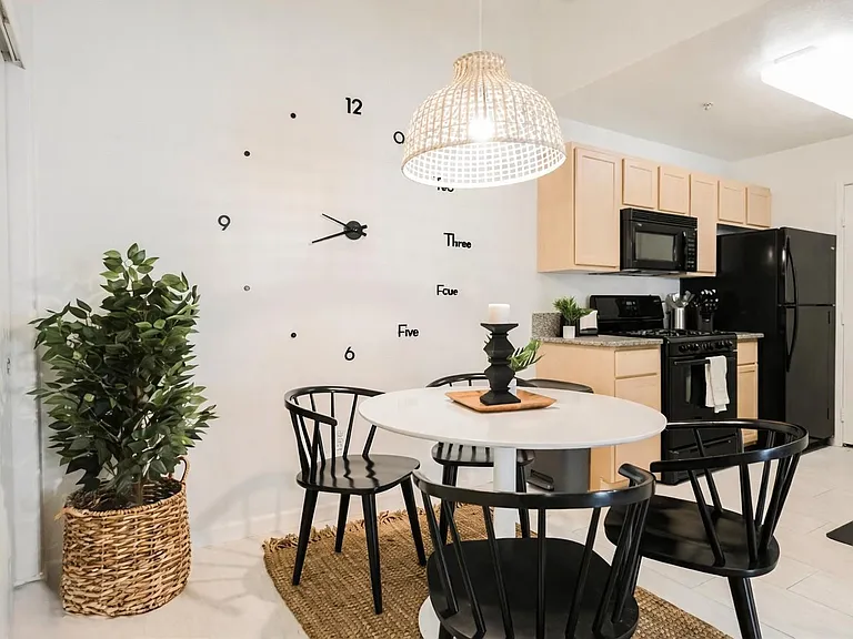 Open dining nook beside the kitchen with a round table, overhead pendant lighting, and convenient access to appliances.