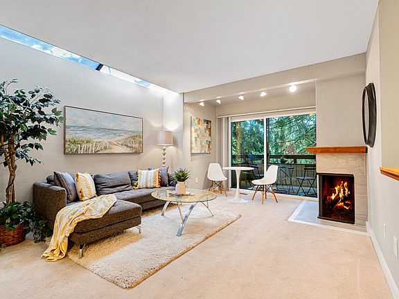 Spacious living room with skylight window and lush green patio