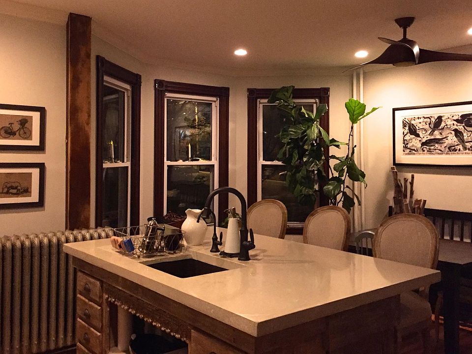 Open-concept kitchen with large island, bar stools, and a turret. Lots of light in each room of this house.