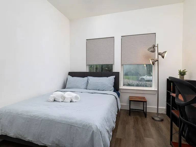 Third bedroom featuring queen bed and designated workspace.