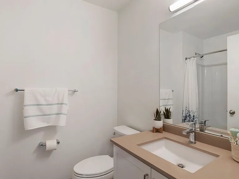 Baths with beige quartz countertops and white cabinetry