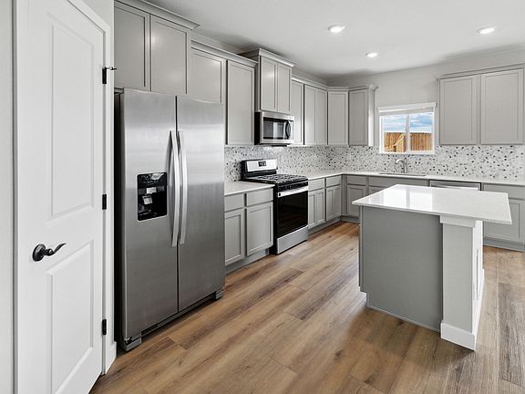 The kitchen of the San Juan plan comes with beautiful wood cabinets and sprawling white countertops.