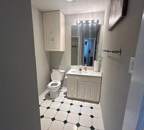 Shared bath has cabinetry for storage and a step-in shower.