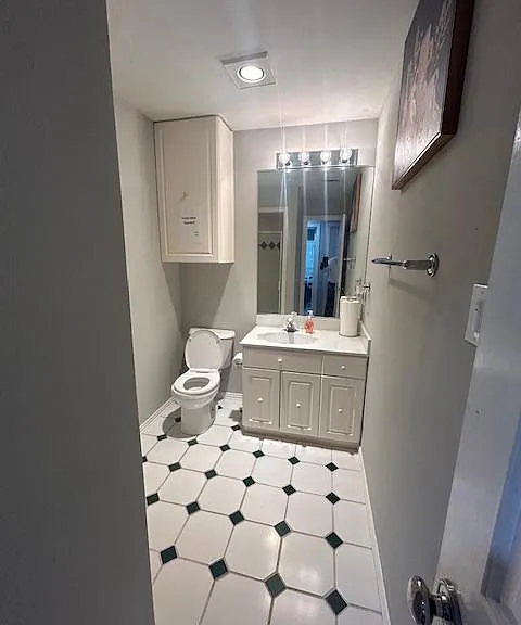 Shared bath has cabinetry for storage and a step-in shower.