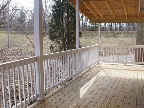 Beautiful covered deck wraps around to a side balcony with a