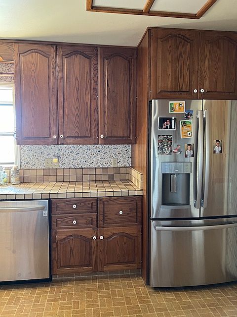 Kitchen with dishwasher and refrigerator and electric range. All appliances are barely used.