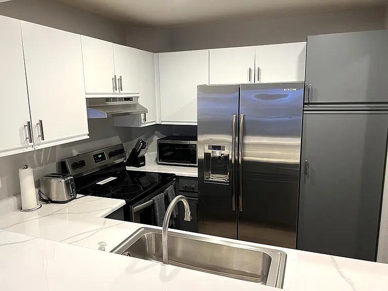 Kitchen with bar with seating for four, stainless appliances, refrigerator with filtered water and ice maker in door, Bosch quiet dishwasher