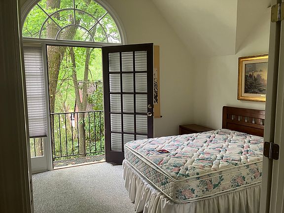 Bedroom overlooks large landscaped garden from balcony