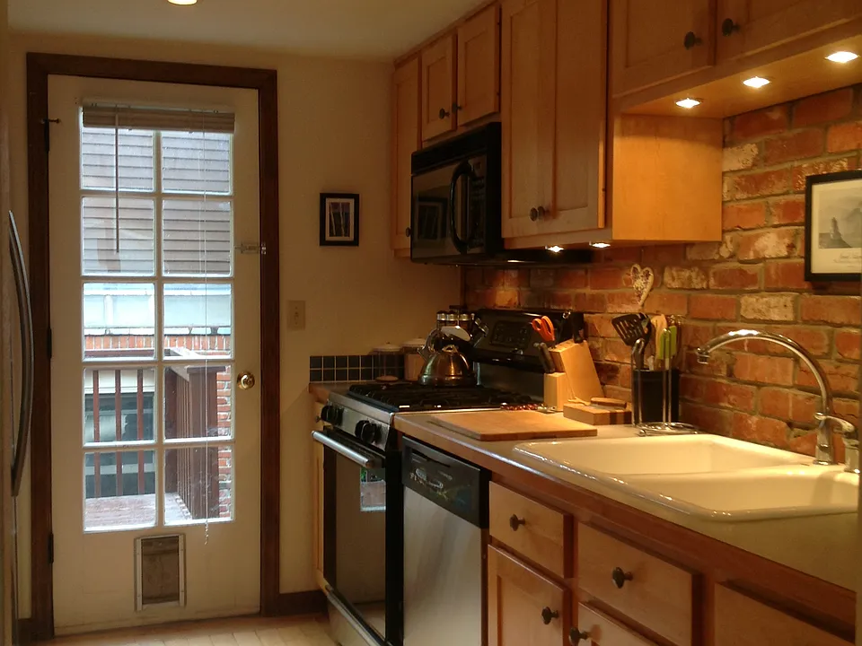 Kitchen includes gas range, dishwasher, and door that opens directly onto a redwood deck.