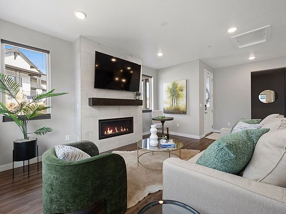 Spacious living room with fireplace and large picture windows with beautiful views of the open space and hillside where elk and deer are often seen grazing.