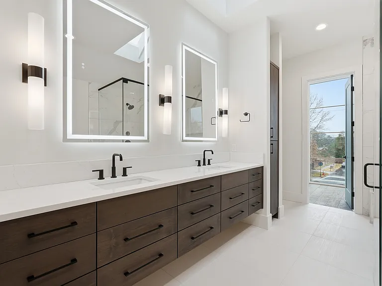 Spa-like primary bathroom with glass enclosed shower, soaking tub, and dual vanity.