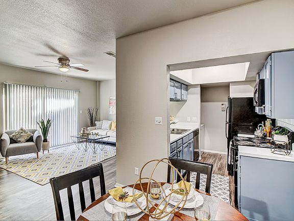 Dining room overlooking kitchen and living room with wood-style flooring
