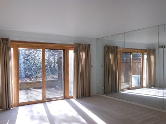 Living room w. mirrored wall and Pella sliding door to the p