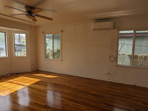 Living room w/ multi-split AC unit and ceiling fans