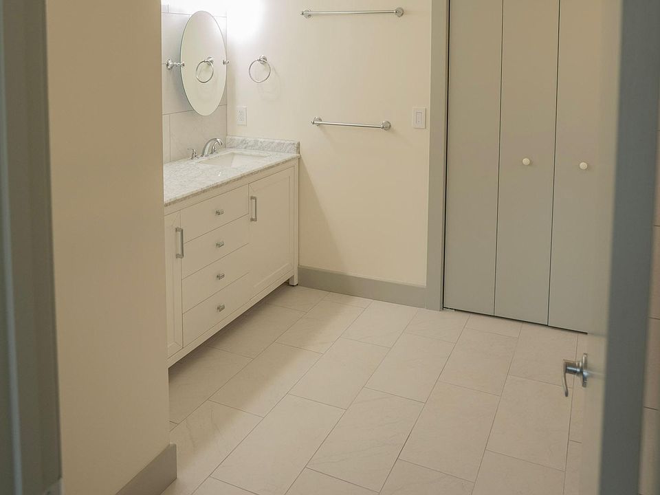 Spacious primary bathroom with marble double vanity and walk-in closet