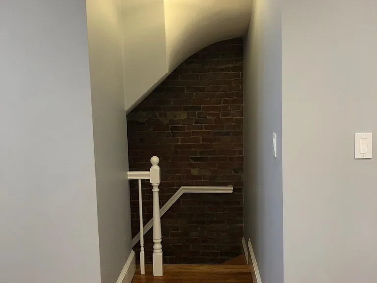 Stairway down to lower level. Beautiful exposed brick.