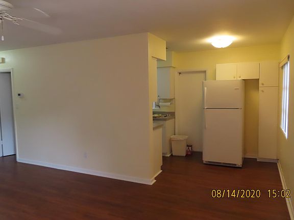From front door looking toward kitchen. Pantry next to refrigerator. Door leads to side yard and area for trash cans