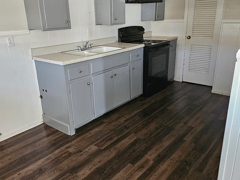 Kitchen with stove. Closet has shelves for storage. Room for a refrigerator and a table.