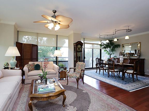 LIVING ROOM LOOKING INTO DINING ROOM. THE LARGE PATIO IS ON THE OTHER SIDE OF THE GLASS WINDOWS.