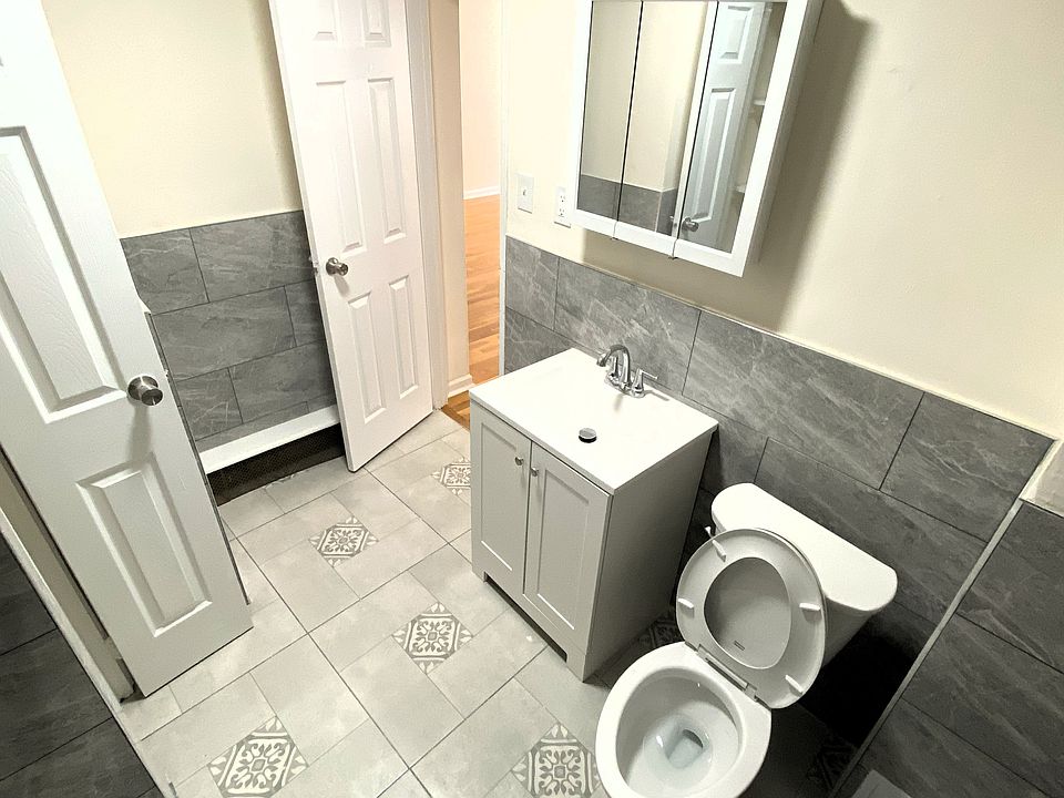 New bathroom with tile floors and linen closet.