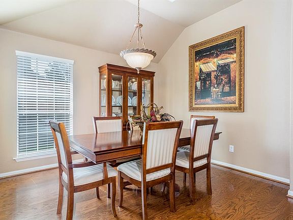 Beautiful formal dining room with hardwood floors and vaulted ceiling.
