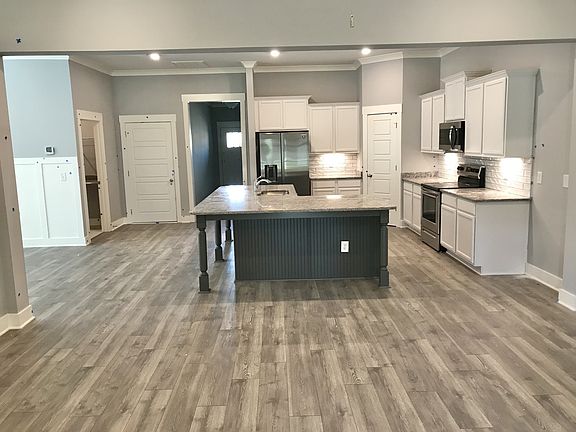 Stock photo looking from great room into kitchen showing large island, corner pantry and included k