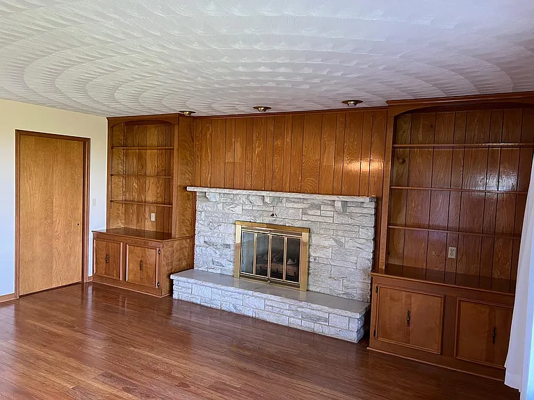 Living room
* Built in shelves and cabinets. 
* Fireplace is non functional. 
* Fireplace doors prevent heat loss. 
* Pocket door for privacy