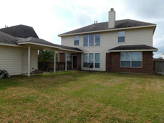 Rear elevation shows covered walkway to detached 2-car garage.