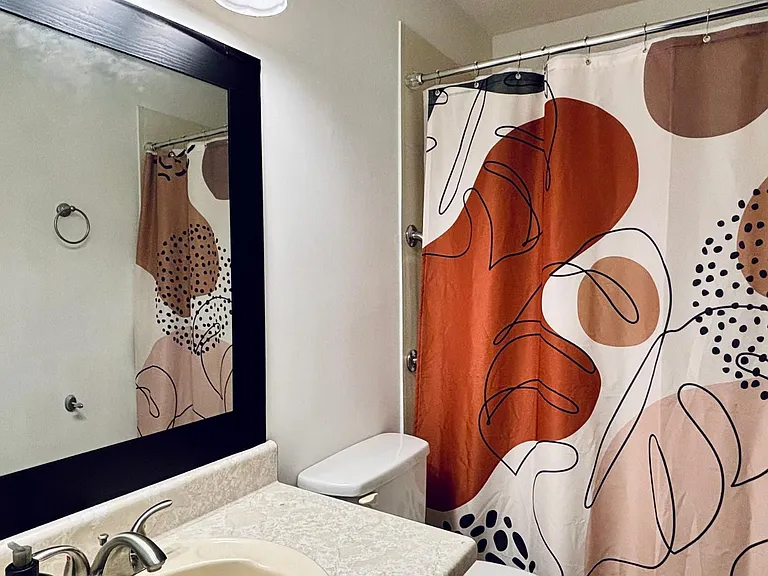 Full bathroom with a single-sink vanity, framed mirror, and tub/shower combo with curtain for easy daily use.