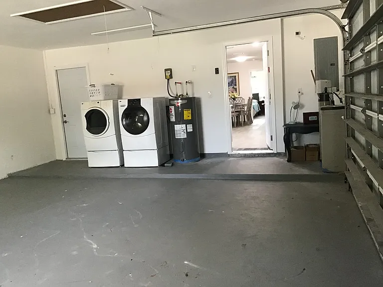 Spacious garage houses a large washer and dryer, water heater and convenient access to the kitchen and backyard.