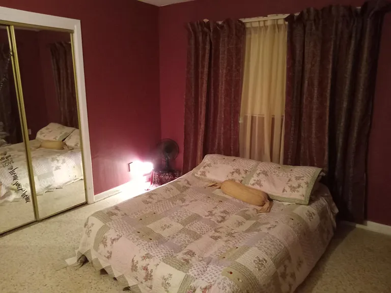 The other side of master bedroom with mirrored closer doors.