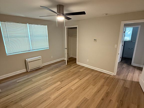 Bedroom w/ new ceiling fan, floors, windows, and new mini-split A/C & heating unit.